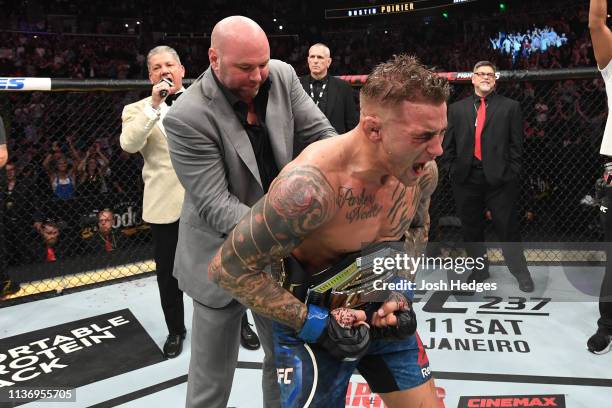 President Dana White places the interim lightweight championship belt on Dustin Poirier after defeating Max Holloway in their interim lightweight...