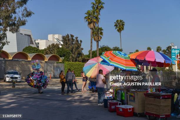 Street vendors work outside the California Science Center at Exposition Park in Los Angeles on March 24, 2019. - "We had to sell, run and hide from...