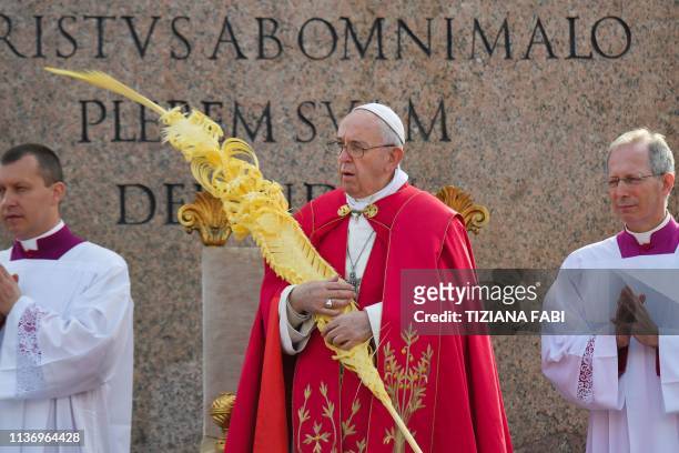Pope Francis holds a woven palm branch at the start of the Palm Sunday mass on April 14, 2019 at St. Peter's square in the Vatican.