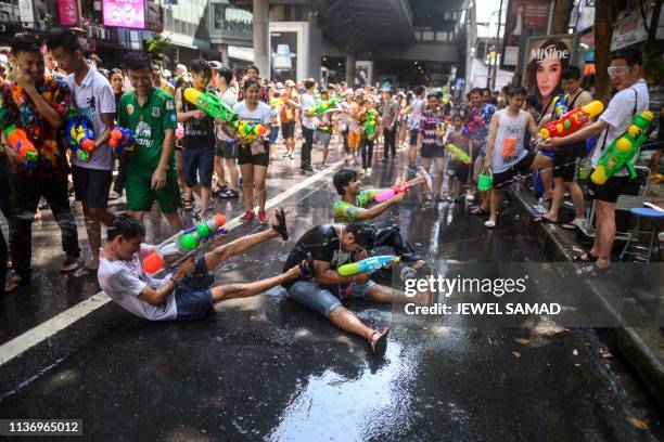 Revellers use water guns to spray at one another as they celebrate the Buddhist New Year, locally known as Songkran, in Bangkok on April 14, 2019.