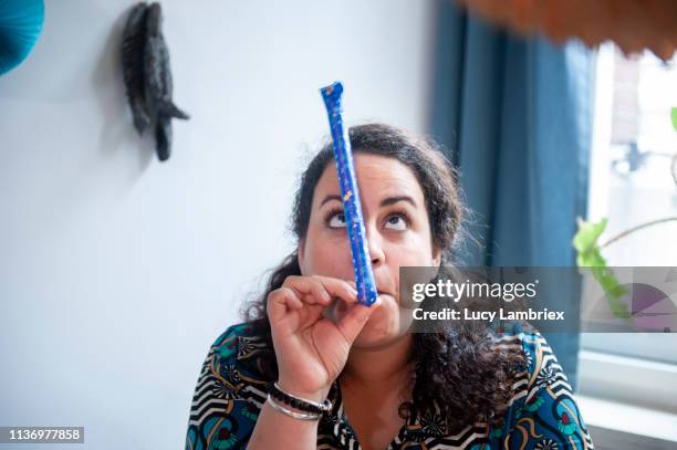 woman playing with a party horn - party favor foto e immagini stock