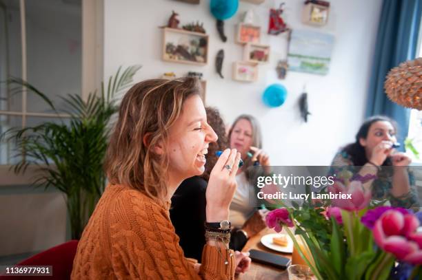 mixed group of women celebrating friend's birthday with a party, playing with party horns - absurd birthday stock pictures, royalty-free photos & images