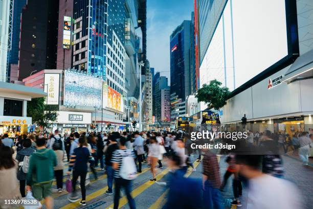 blurred motion of busy commuters crossing street in downtown district during office rush hours in the city - hongkong stock pictures, royalty-free photos & images