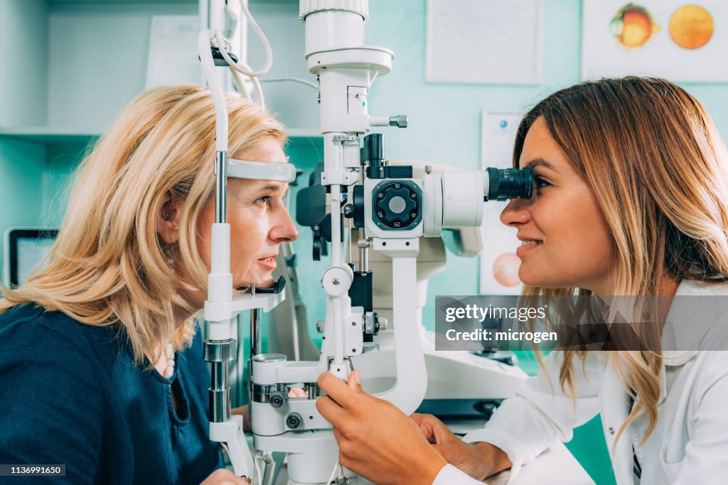 Optometrist Examining Patient At Clinic