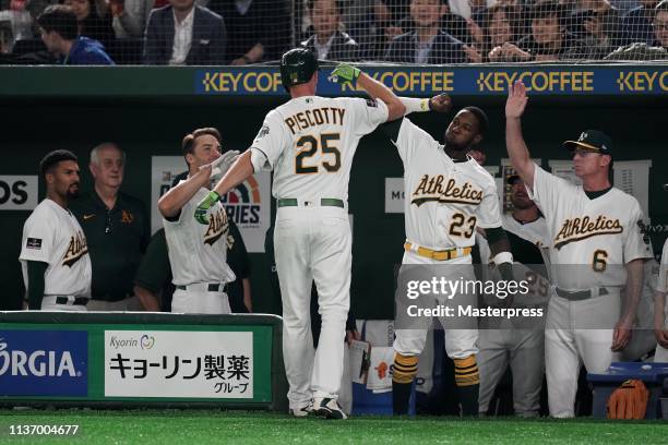 Outfielder Stephen Piscotty of the Oakland Athletics is congratulated by team mates after hitting a solo homer to make it 0-1 in the 1st inning...