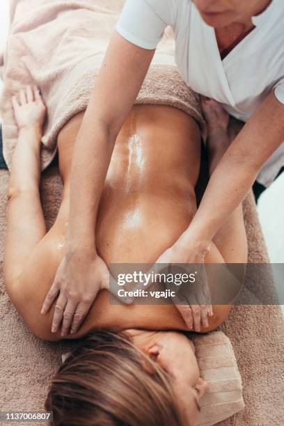 woman enjoy professional back massage - massage therapy stock pictures, royalty-free photos & images