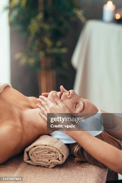 woman with closed eyes enjoy face massage - facial massage stock pictures, royalty-free photos & images