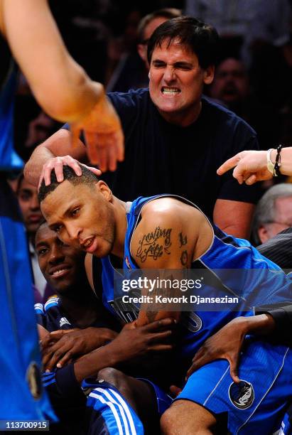 Owner Mark Cuban of the Dallas Mavericks rubs the head of Shawn Marion of the Dallas Mavericks as he falls into the bench as the Mavericks take on...