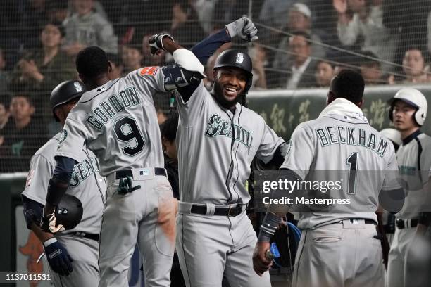 Outfielder Domingo Santana of the Seattle Mariners celebrates hitting a grand slam to make it 5-2 with his team mates in the 3rd inning during the...