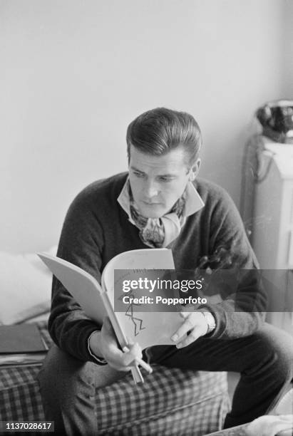 English actor Roger Moore , who plays the character of Simon Templar in the television drama series 'The Saint', pictured reading the script for the...