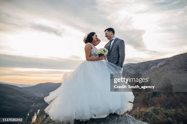 happy newlywed couple on mountain - wedding dress stock pictures, royalty-free photos & images