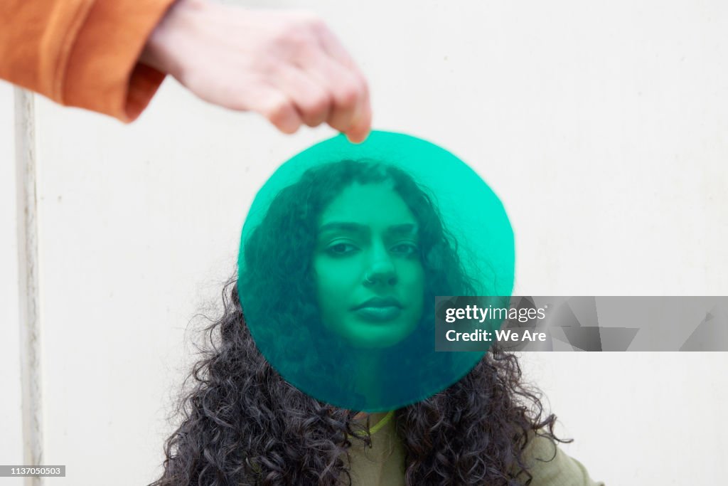 Portrait of young woman shot through green cellophane