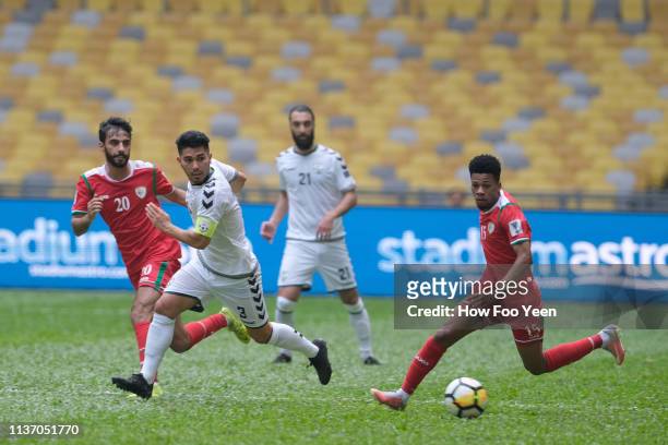 Jameel Saleem Jameel Al Yahmadi of Oman and Hassan Amin of Afghanistan in action during the Airmarine Cup match between Oman and Afghanistan at Bukit...