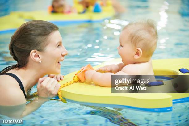 he’s enjoying her first dip in the pool - baby swim imagens e fotografias de stock