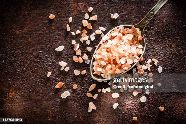 himalayan salt in a spoon shot from above - himalayan salt stock pictures, royalty-free photos & images