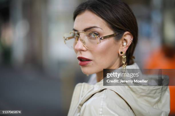Masha Sedgwick wearing Celine glasses, Tiffany & Co earring, 8 by yoox beige vinyl coat on March 19, 2019 in Berlin, Germany.