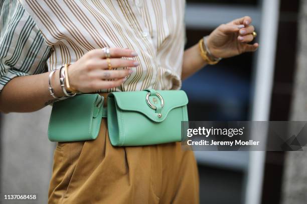 Masha Sedgwick wearing Bally wide pants, Sandro stripes shirt, Bash mustard yellow coat, green Aigner belt bag, Marc Jacobs sunnies, Tiffany & Co...