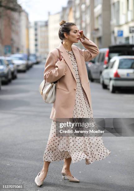 Masha Sedgwick wearing nude Baum und Pferdgarten maxi dress with dots and ruffles, oversized Joseph pink blazer, Tory Burch bucket bag, Maria Black...