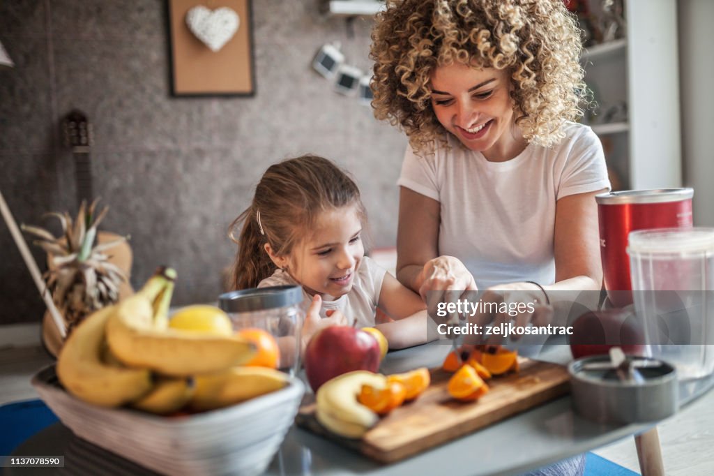 Mother and daughter making smoothie