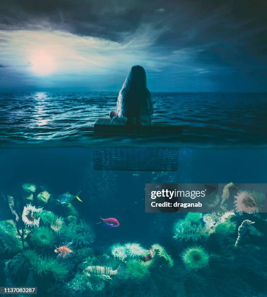 klein meisje zwevend op de zee - girl full moon stockfoto's en -beelden