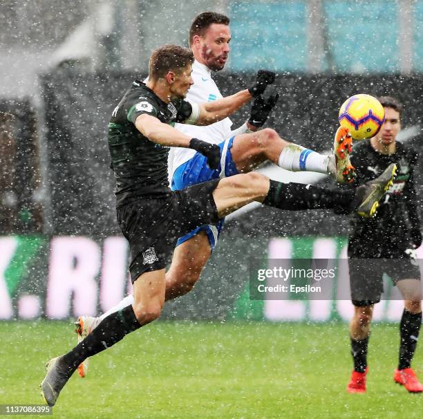 Evgeniy Markov of FC Dinamo Moscow vies for the ball with Alyaksandr Martynovich of FC Krasnodar during the Russian Premier League match between FC...