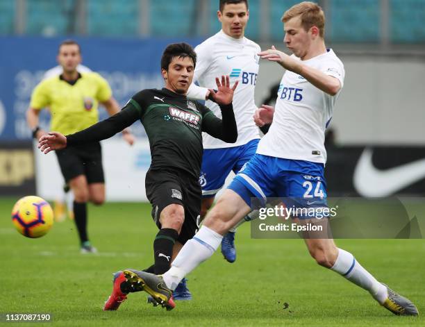 Roman Evgenyev of FC Dinamo Moscow vies for the ball with Magomed-Shapi Suleymanov of FC Krasnodar during the Russian Premier League match between FC...