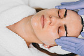 woman receiving facial treatment at beauty salon. Exfoliation
