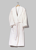 A white hung up bathrobe on a grey wall