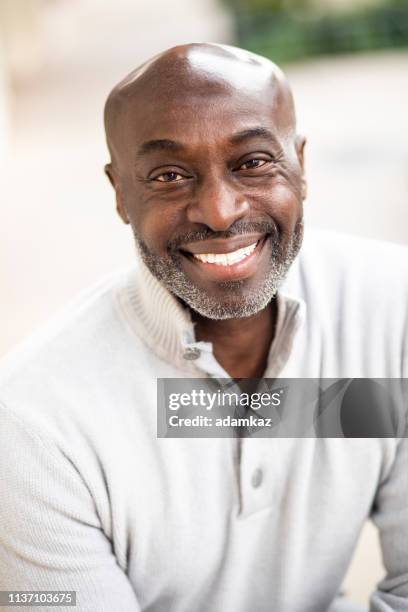 portrait of a mature senior black man sitting and laughing - actor headshot stock pictures, royalty-free photos & images