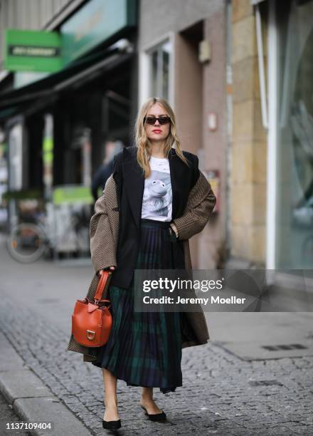 Olja Ryzevski wearing T-shirt, Skirt and blazer von Sandro Paris, Shoes Jacquemus via Luisaviaroma, Coat Andersson Bell, Sunglasses ace&tate, Bag...