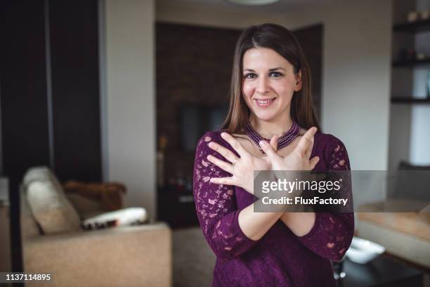 smiling deaf woman doing sign language - butterfly sign - butterfly hand imagens e fotografias de stock