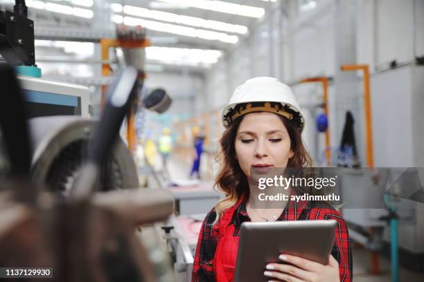 ingeniero de mantenimiento femenino joven que trabaja con tabletas digitales - mechatronics fotografías e imágenes de stock