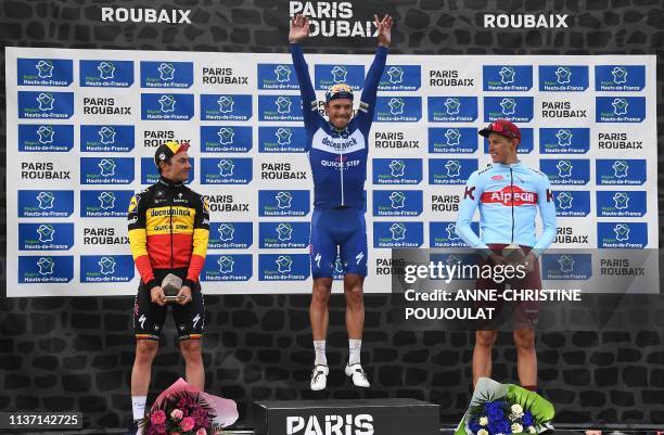 Winner Belgium's Philippe Gilbert celebrates his victory next to second-placed Germany's Nils Politt and third-placed Belgium's Yves Lampaert on the...