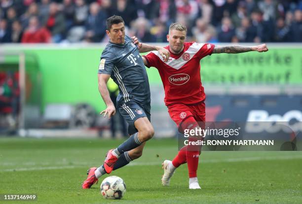 Bayern Munich's Polish forward Robert Lewandowski and Duesseldorf's German defender Andre Hoffmann vie for the ball during the German first division...