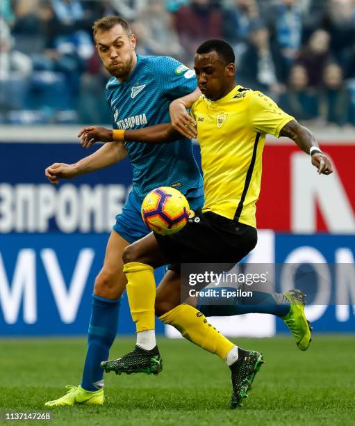 Artem Dzyuba of FC Zenit Saint Petersburg and Gael Ondoua of FC Anji Makhachkala vie for the ball during the Russian Premier League match between FC...