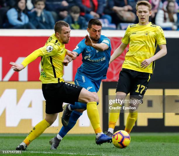 Robert Mak of FC Zenit Saint Petersburg vies for the ball with Vladislav Kulik and Ivan Ivanchenko of FC Anji Makhachkala during the Russian Premier...