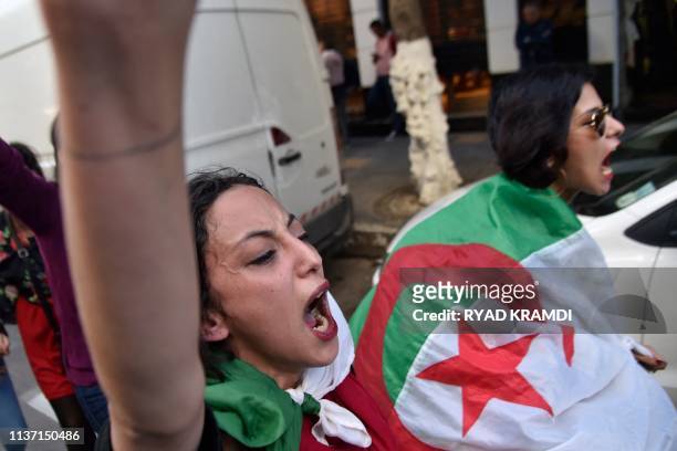 An Algerian woman wearing her national flag shouts as protesters demonstrate near Emir Abdelkader square in Algiers on April 14, 2019. Mass protests...