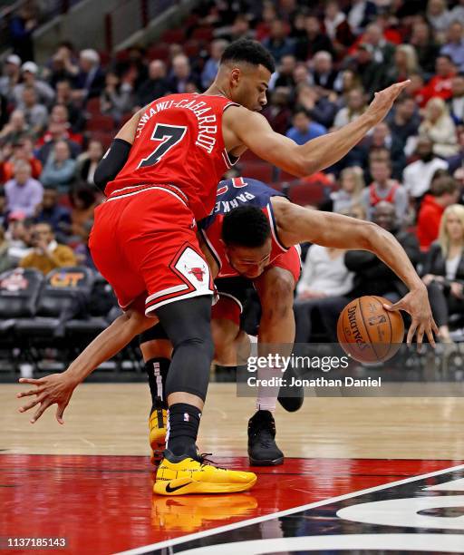 Jabari Parker of the Washington Wizards slips as he moves against Timothe Luwawu-Cabarrot of the Chicago Bulls at the United Center on March 20, 2019...