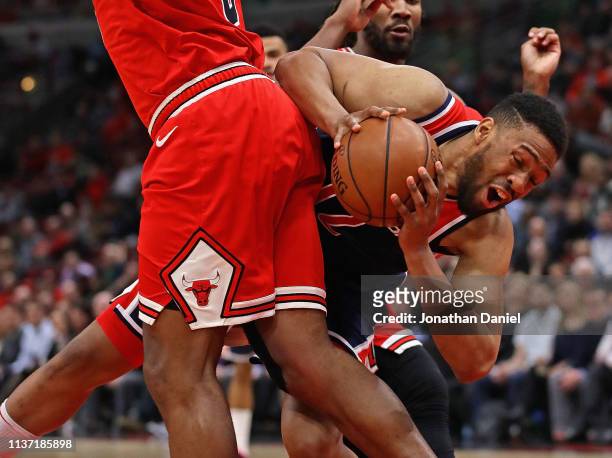 Jabari Parker of the Washington Wizards falls as he tries to moves against Cristiano Felicio of the Chicago Bulls at the United Center on March 20,...