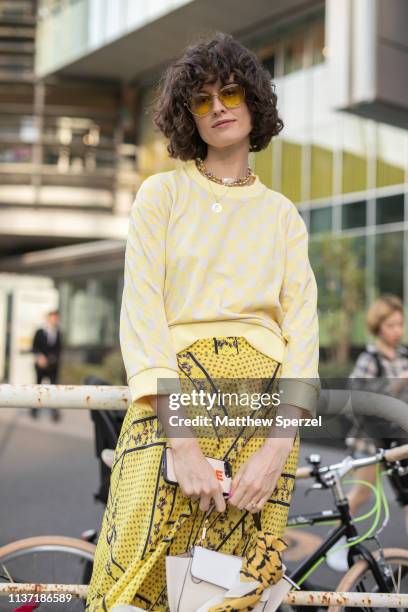 Chloe Hill is seen wearing yellow sweater and yellow design skirt with white bag and cowgirl boots during the Amazon Fashion Week TOKYO 2019 A/W on...