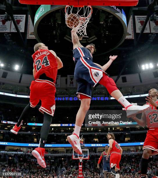 Tomas Satoransky of the Washington Wizards dunks over Lauri Markkanen of the Chicago Bulls at the United Center on March 20, 2019 in Chicago,...