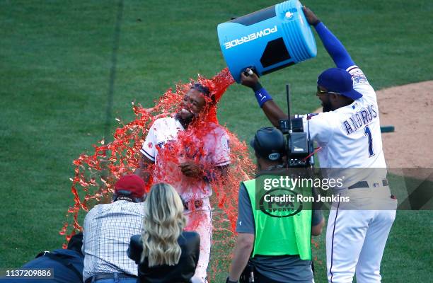 Delino DeShields is doused with Powerade by teammate Elvis Andrus of the Texas Rangers following the team's 8-7 win over the Oakland Athletics at...