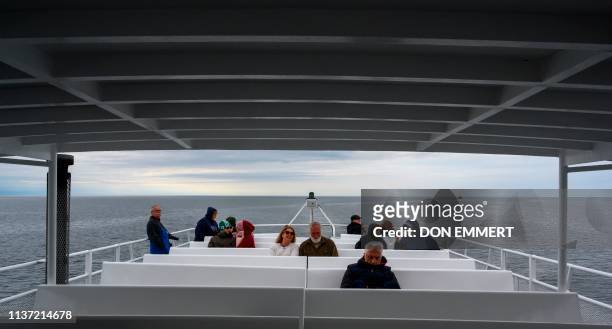 Passengers aboard the whale watching boat Dolphin IX talk about their day's adventures while searching for the North Atlantic right whale in the...