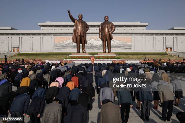 People bow as they pay their respects before the statues of late North Korean leaders Kim Il Sung and Kim Jong Il, as part of celebrations marking...