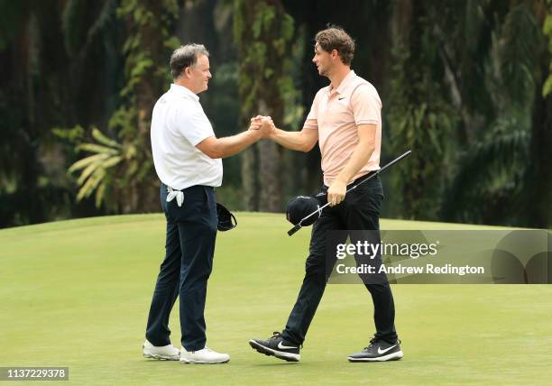 Marcus Fraser of Australia and Thomas Pieters of Belgium shake hands on the ninth hole on Day One of the Maybank Championship at Saujana Golf &...