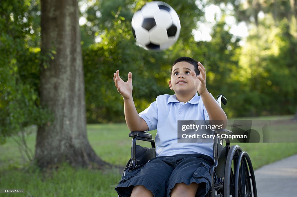 Hispanic boy, 8, in wheelchair with soccer ball