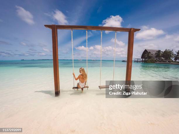 donna bionda seduta su un'altalena alle maldive - sud foto e immagini stock