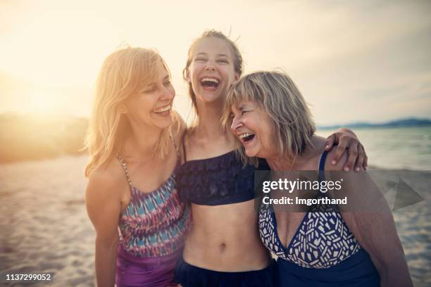 grandmother, mother and daughter enjoying time together on a beach - body positive mother stock pictures, royalty-free photos & images