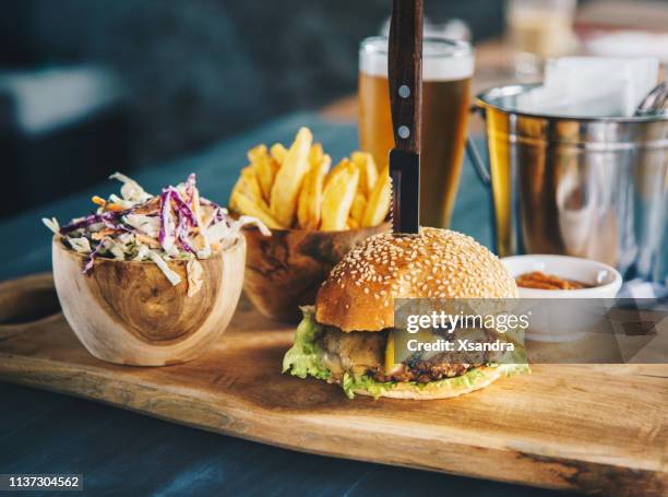 klassischer rindfleischburger mit pommes frites und coleslaw-salat - kneipengericht stock-fotos und bilder