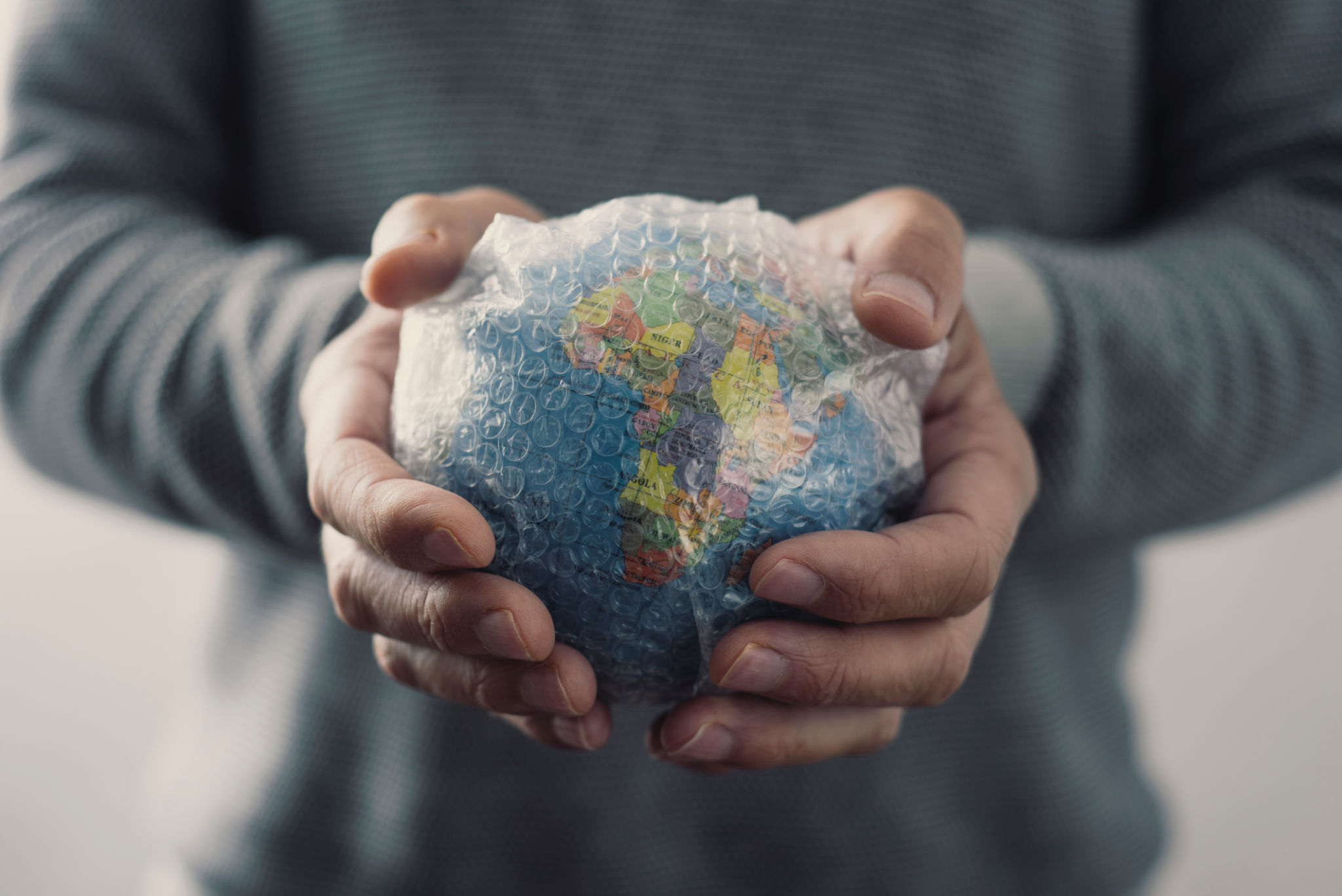man with a world globe wrapped in bubble wrap man with a world globe wrapped in bubble wrap